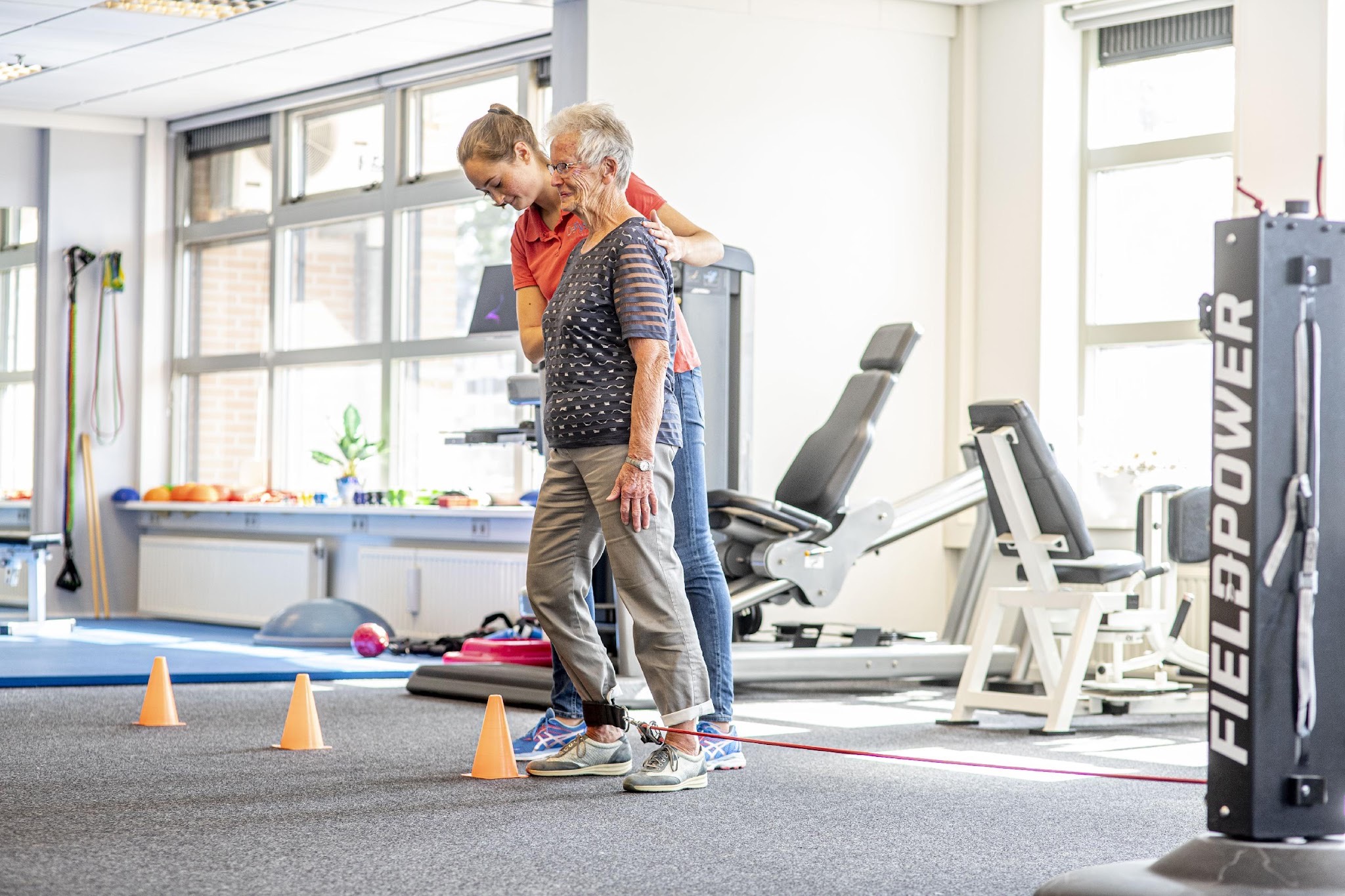 FieldPower Therapie mit rotem Widerstandsband zwischen Fuß und FieldPower Gerät